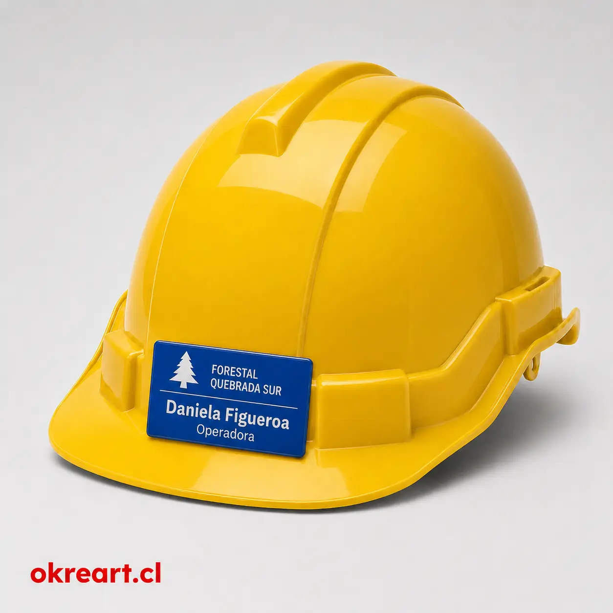 Placa azul para casco de seguridad de 7x3 cm en casco amarillo, vista ladeada, personalizada con nombre y cargo.