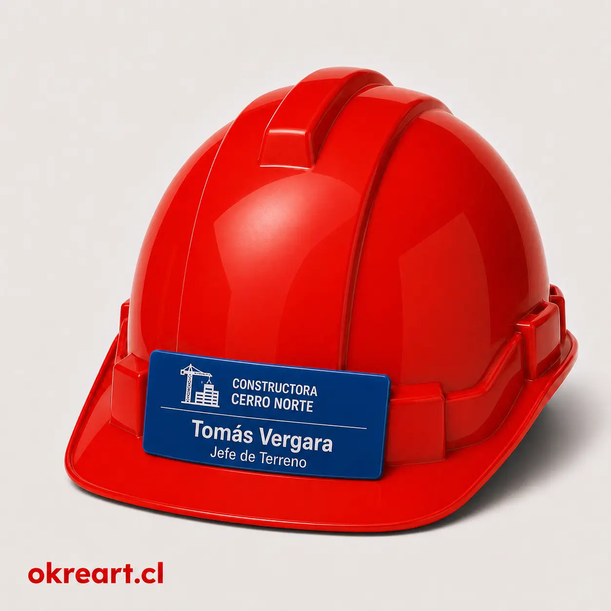 Placa azul para casco de seguridad de 8x3 cm en casco rojo, vista ladeada, personalizada con nombre y cargo.