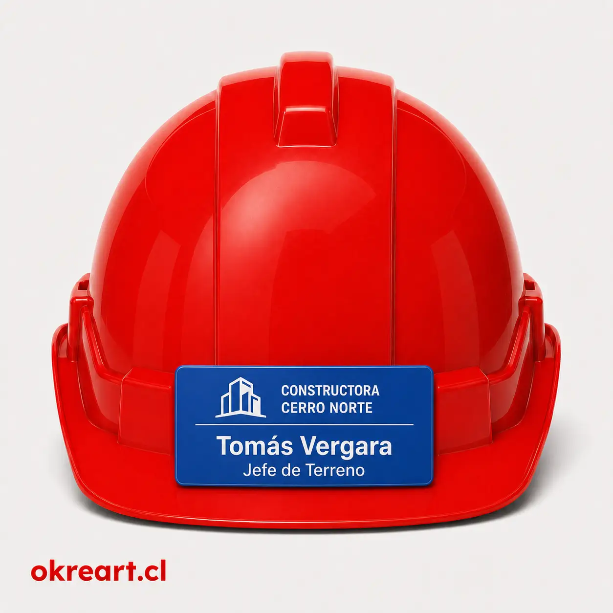 Placa azul para casco de seguridad de 8x3 cm en casco rojo, vista frontal, personalizada con nombre y cargo.