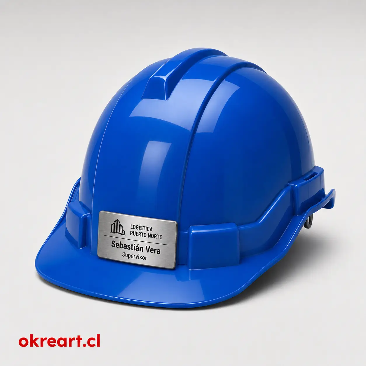 placa plateada para casco de seguridad de 6x3 cm en casco naranjo, vista ladeada, personalizada con nombre y cargo