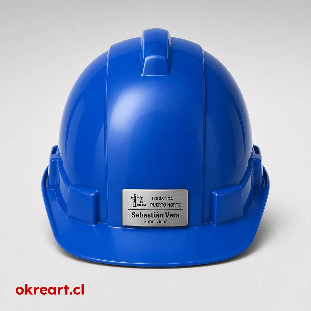 placa plateada para casco de seguridad de 6x3 cm en casco naranjo, vista frontal, personalizada con nombre y cargo