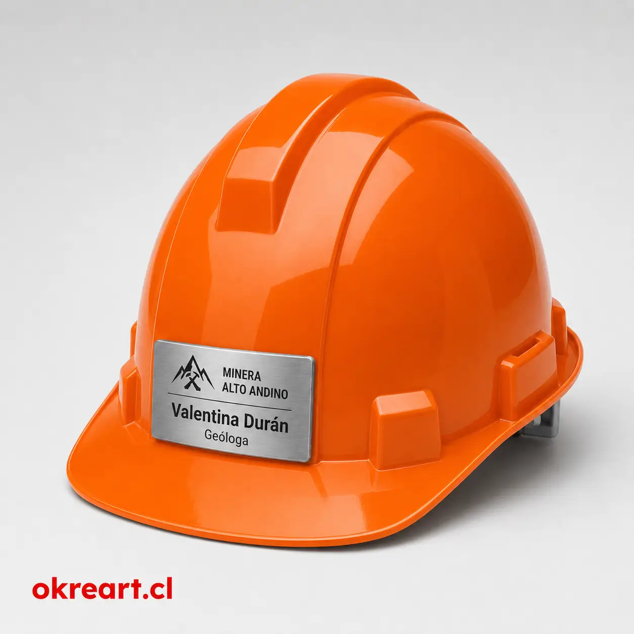 placa plateada para casco de seguridad de 7x3 cm en casco naranjo, vista ladeada, personalizada con nombre y cargo