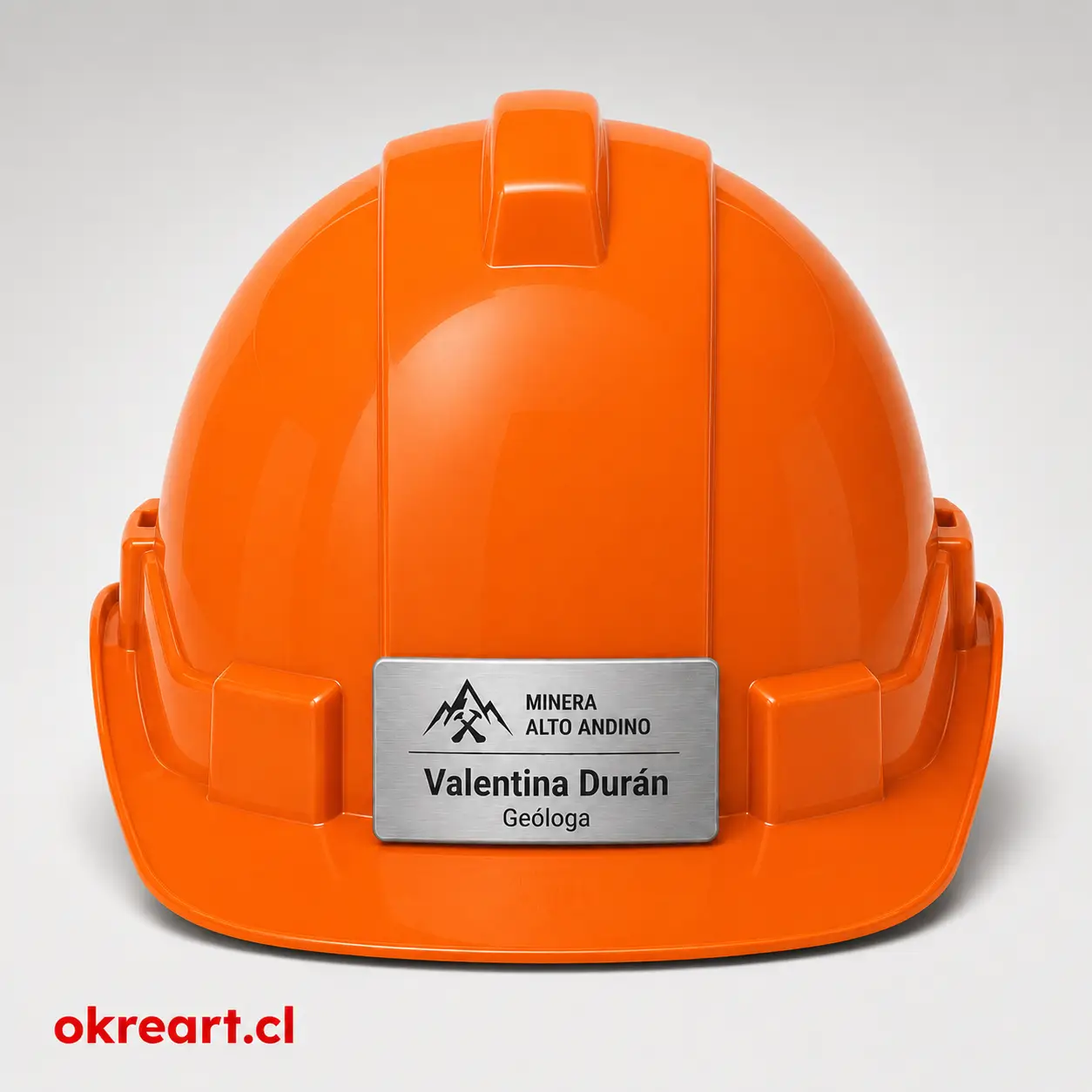 Placa plateada para casco de seguridad de 7x3 cm en casco naranjo, vista frontal, personalizada con nombre y cargo