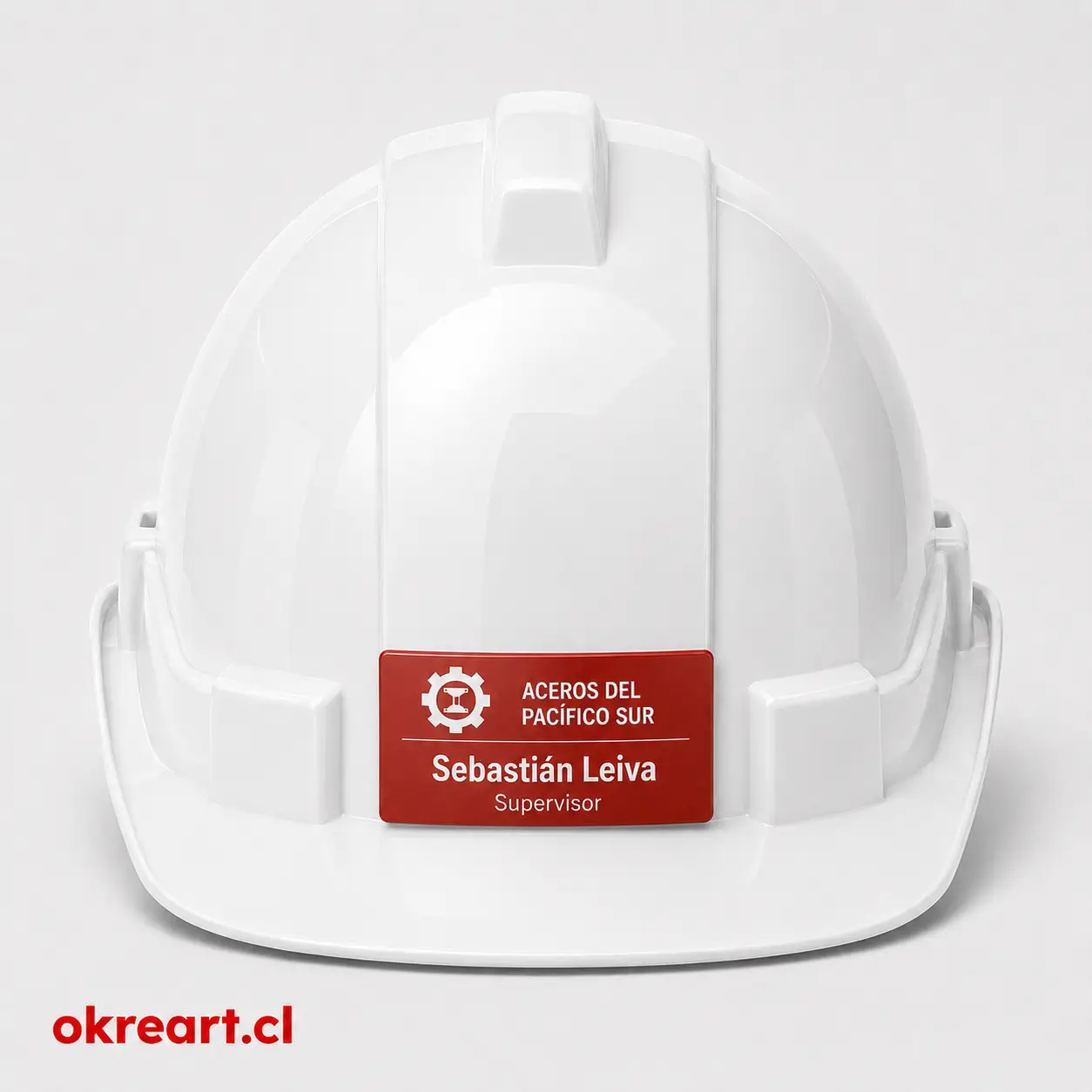 Placa roja para casco de seguridad de 7x3 cm en casco blanco, vista frontal, personalizada con nombre y cargo.